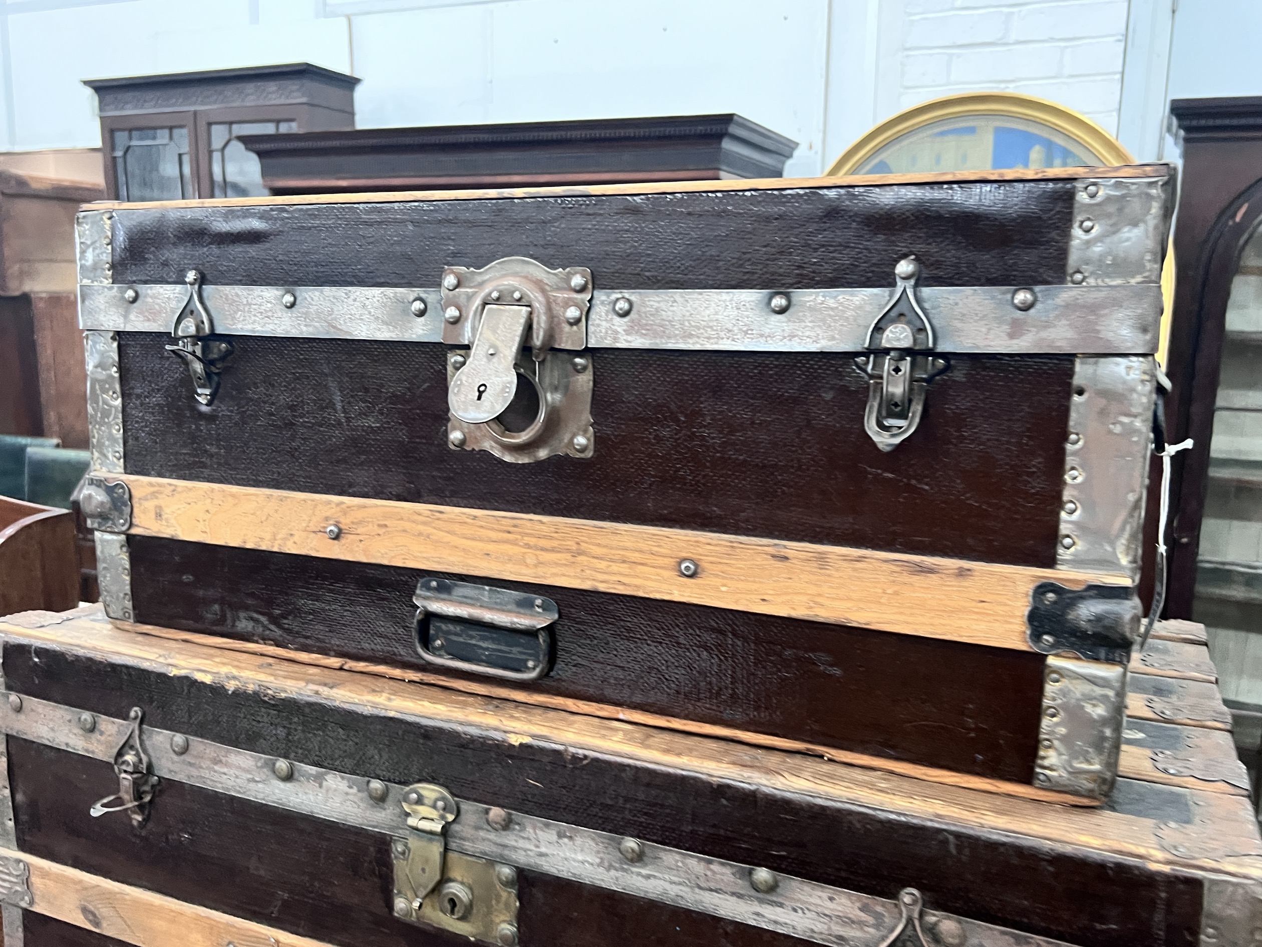 Two wood and metal bound travelling trunks, larger length 86cm, depth 48cm, height 47cm